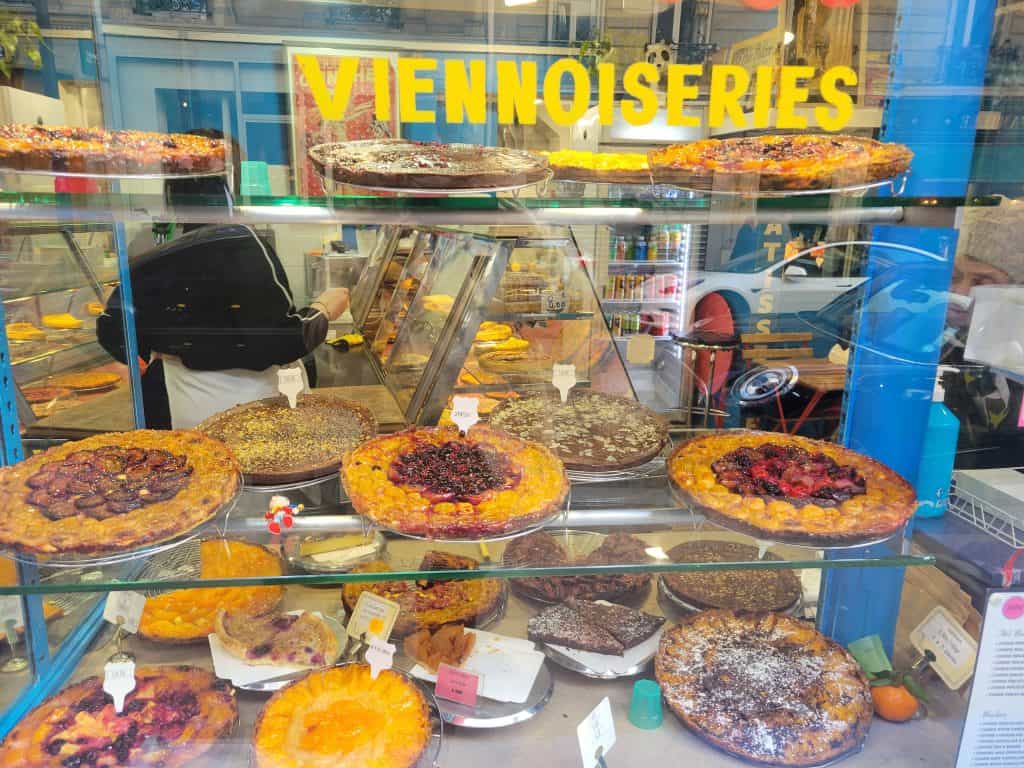 Window filled with homemade pies and pastries in one of the hidden gem bakeries in Paris.
