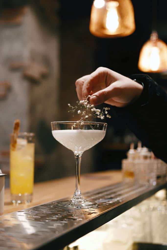 Elegant cocktail in a moody speakeasy like Moonshiner in Paris.